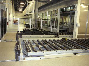 Chain driven live roller conveyors with chain transfers for auto chassis assembly